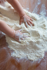 Child's hands playing with the flour