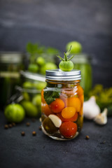 Vegetables tomatoes, cucumbers, green beans with spices in jars.