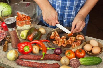 Slicing onions and tomatoes. Preparing diet meals. Chef slicing vegetables for a salad.
