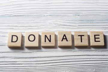 text of DONATE on cubes. Wooden abc.