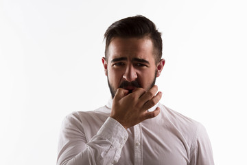Handsome man whistling isolated on white background. Brunette hipster man in white shirt posing in...