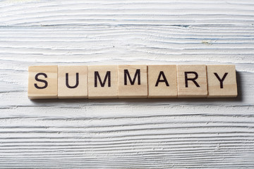 SUMMARY word written on wood block at wooden background