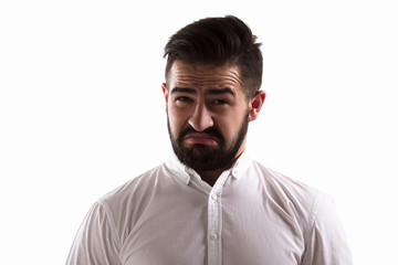 Image of hatred handsome man looking at camera. Bearded hipster man posing for photographer isolated on white background in studio.