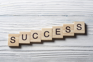 Success word written on wood abc block at wooden backround