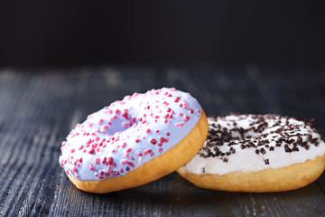 Donuts with blue and vanilla icing on a dark background