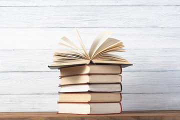 Open book, hardback books on wooden table. Education background. Back to school. Copy space for text.