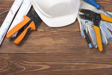 Set of electrical tool on wooden background. Accessories for engineering work, energy concept.