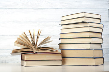 Open book, hardback books on wooden table. Education background. Back to school. Copy space for text.