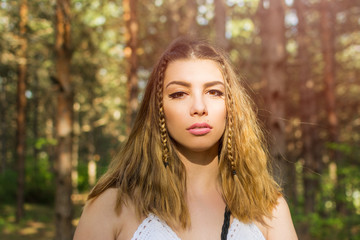 Beautiful young blonde boho woman with braids outdoors in nature. Closeup, natural light