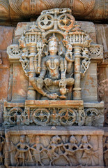 The carved sandstone ancient indian goddess on the outer wall of Hindu Temple, 11 century, in Ranakpur, India