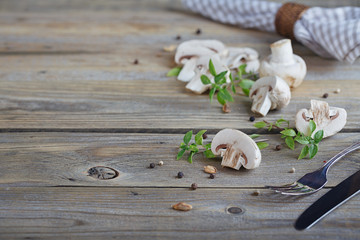 Fresh mushrooms and basil on rustic wooden background.