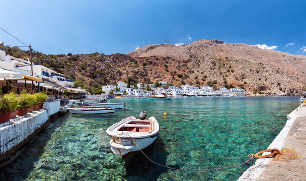 Small motorboat at clear water bay of Loutro town on Crete island
