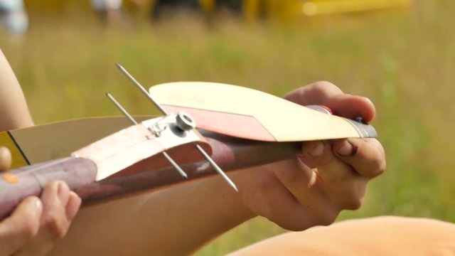 Boy is Checking an Aircraft Propeller Rubber Model Sports Competition Young Man's Hands Konotop Sunny Day Preparation For Airplane Launch Models Assembly