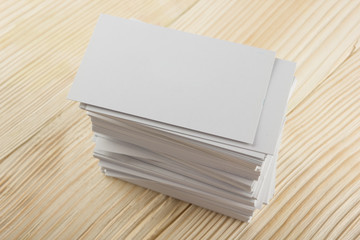 White blank business visit card, gift, ticket, pass, present close up on wooden background. Copy space corporate identity package Template for ID