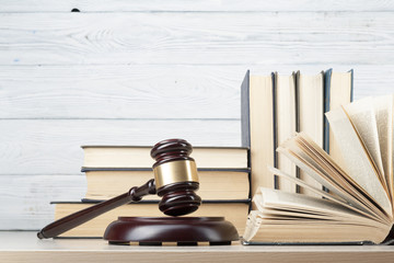 Law concept - Book with wooden judges gavel on table in a courtroom or enforcement office.