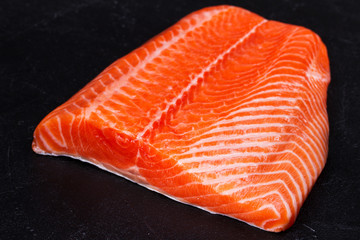 Raw fresh salmon fish on black background