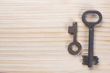 Real estate concept. Silver key with copy space for ad text and blank business note pad on wooden background. Top view.