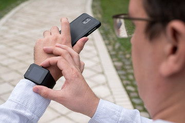 Man using smart watch outdoors