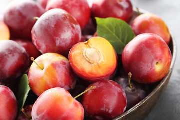 Fresh plums on a grey wooden table