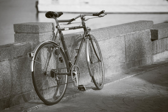 close up vintage bicycle laying near a wall,sepia process,black and white picture style,dark edges,selective focus