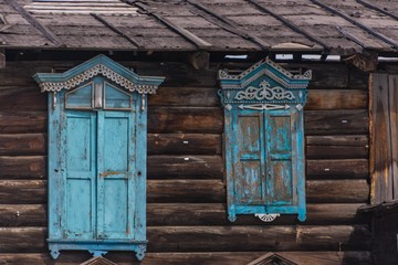 Fototapeta na wymiar Sibirisches Holzhaus mit blauen Fenstern