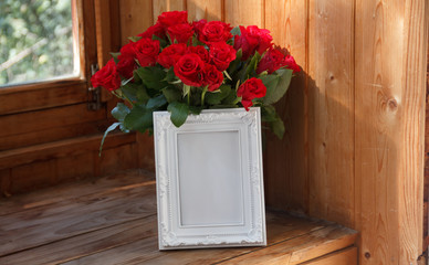 White frame and bunch of red roses