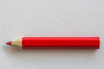 Red pencil on paper background