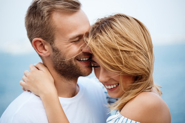 Fototapeta premium Young beautiful couple smiling, rejoicing, sea background.