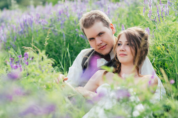 portrait of the bride and groom resting on a lavender background