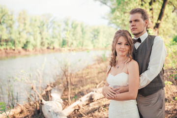 bride and groom standing on a background of grass  lakes