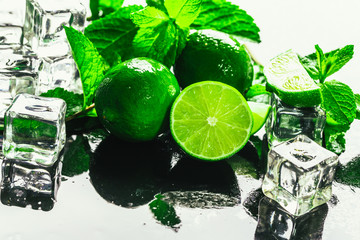 fresh green mint and lime ice cube close-up on a dark background