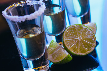 stack of tequila with salt close up on blurred background