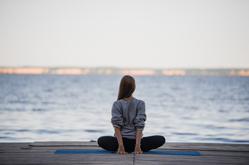 Image of a pretty woman doing yoga at the lake