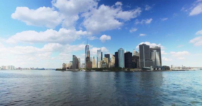 A daytime establishing shot of the lower Manhattan skyline as seen from New York harbor.  	