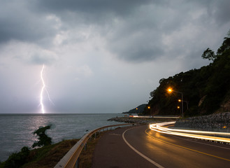Noen-nangphaya view point, Landmark at Chanthaburi, Thailand: lightning thunderbolt in sea at twilight with lighting from cars