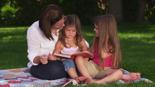 Mother and daughters having a picnic in the park - 4k