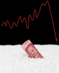 RMB paper currency sink into polystyrene particle and a fluctuation graphic on background monetary concept