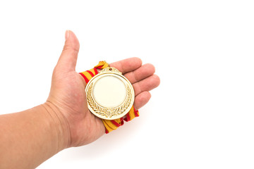 gold medal on males hand on a white background