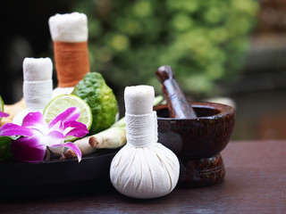 Fototapeta na wymiar Natural Spa Ingredients herbal compress ball and herbal Ingredients for alternative medicine and relaxation Thai Spa theme with silk fabric , soft and select focus 