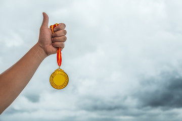 Fototapeta na wymiar man lifting a gold medal with the thumb up