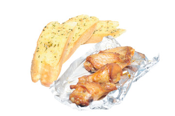 Garlic breads in row with Barbecue chicken wings in foil paper