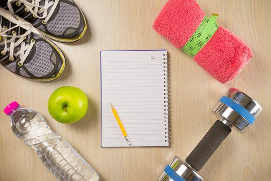 Sport and fitness objects and space notepad on wooden background - Exercise, Health care and diet target plan concept