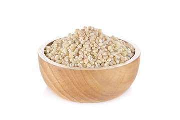 Uncooked barley grain seeds in wooden bowl and on white backgrou