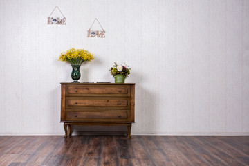 Vase with flovers on dresser in home inrerrior