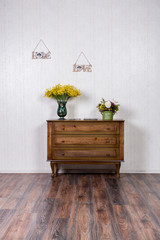 Vase with flovers on dresser in home inrerrior