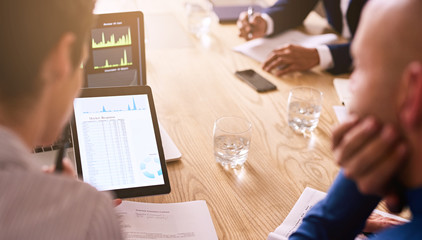 Business meeting taking place with diverse group of business people in a modern office with several...