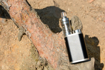 Electronic cigarette at the root of the tree