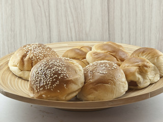 The pile of breads in the wooden dish.