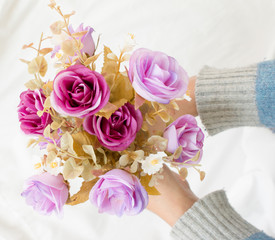 Purple artificial bouquet in girl's hands