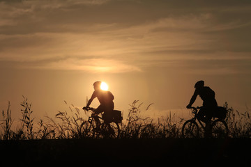 Riding a bike in sunset - 118946281